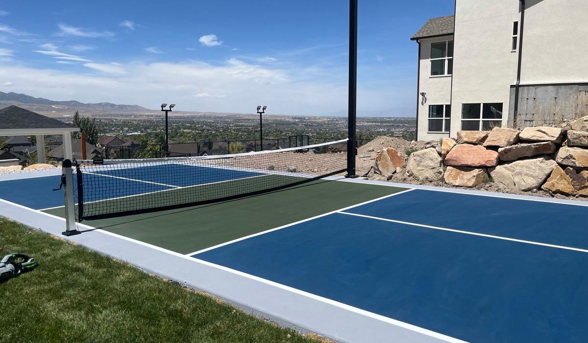 Pickleball court on the south Herriman bench with a boulder retaining wall and the valley beyond