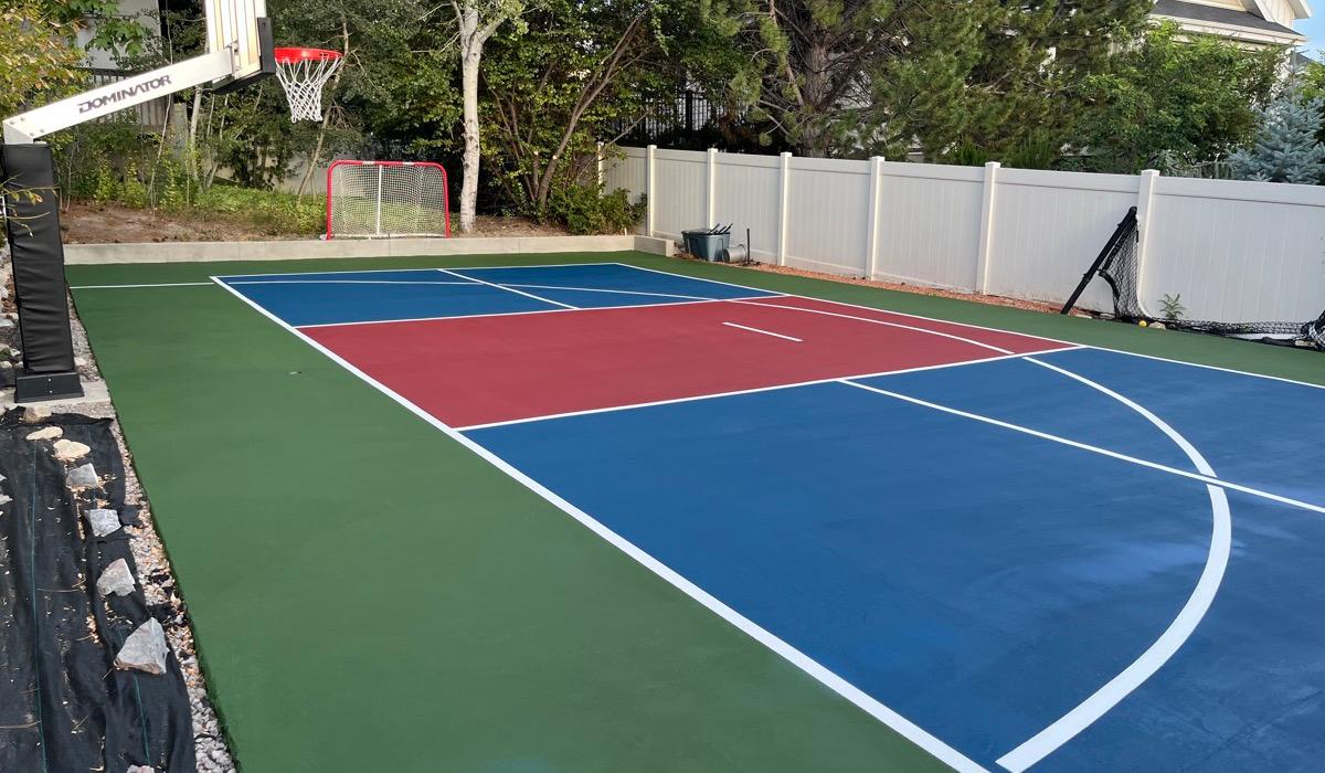 Multi-sport court in Pleasant Grove with a red non-volley zone inside a grass green apron