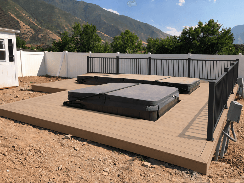 Finished composite deck with wrought iron railing, mountains beyond.