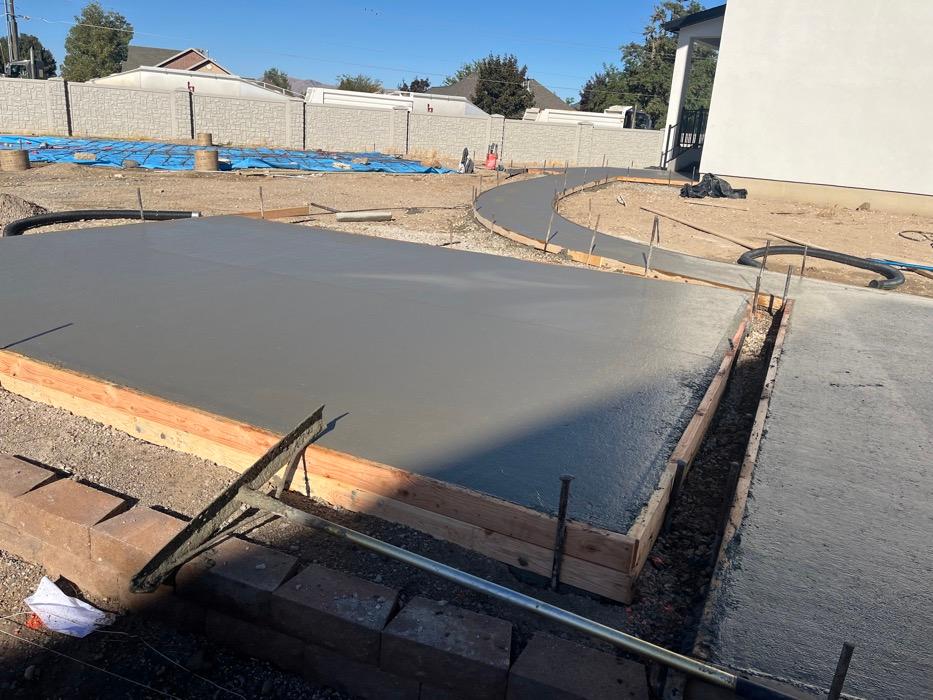 Fresh concrete pour in Salem with timber forms and rebar at the edge and a curved return formed into one corner.