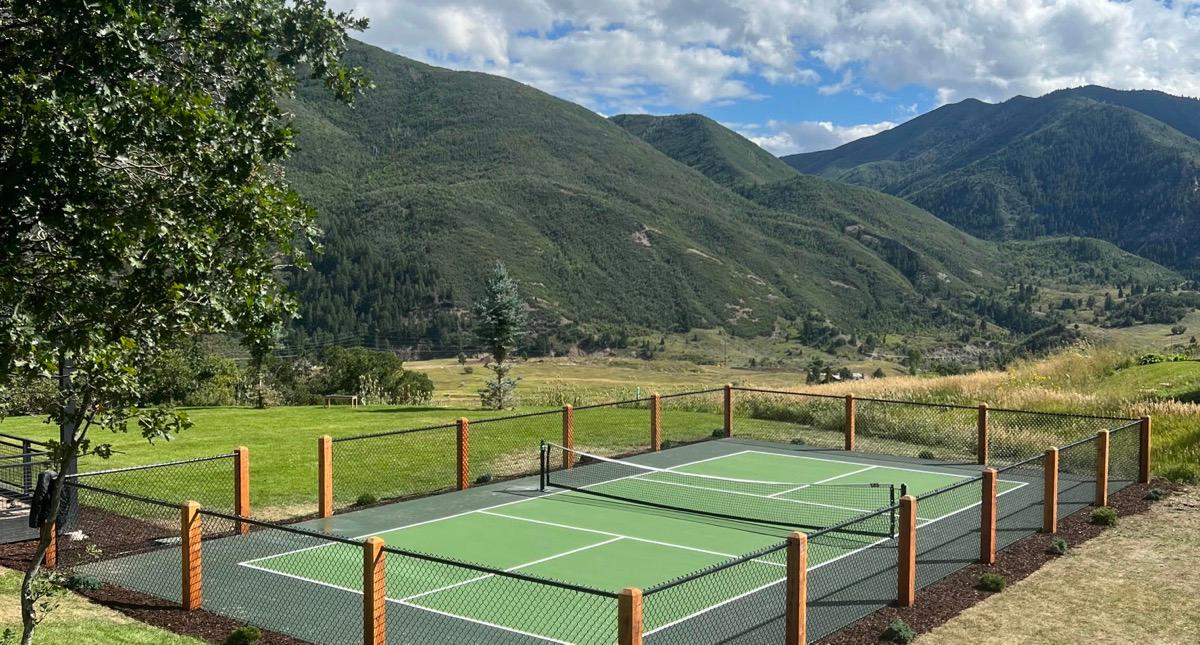 Pickleball court in Heber City with green surfacing and cedar fence posts.