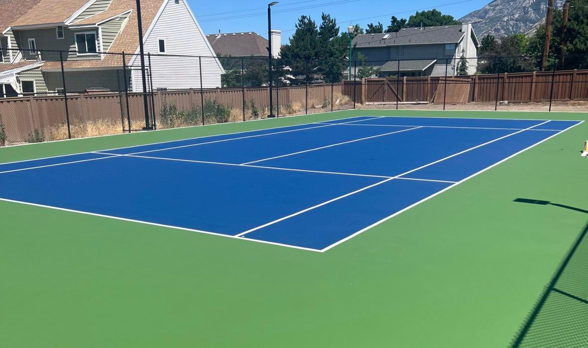 Tennis court in Orem with a blue playing surface and a green surround.